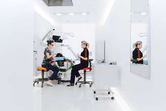 Close-up profissional de uma prótese dentária sendo examinada por um dentista para orientar a higienização